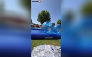 Little kids inside an inflatable zorb ball gets launched into space during a windy day