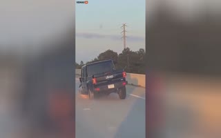 Jeep Gladiator Drives Down The Highway With The Front Wheel Missing